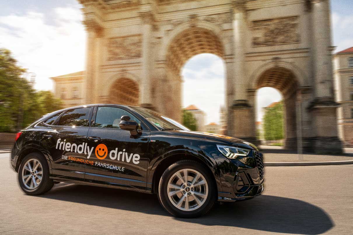 Auto-Führerschein in München bei Friendly Drive Friendly Drive Fahrschulauto vor dem Siegestor in München für den Auto-Führerschein.