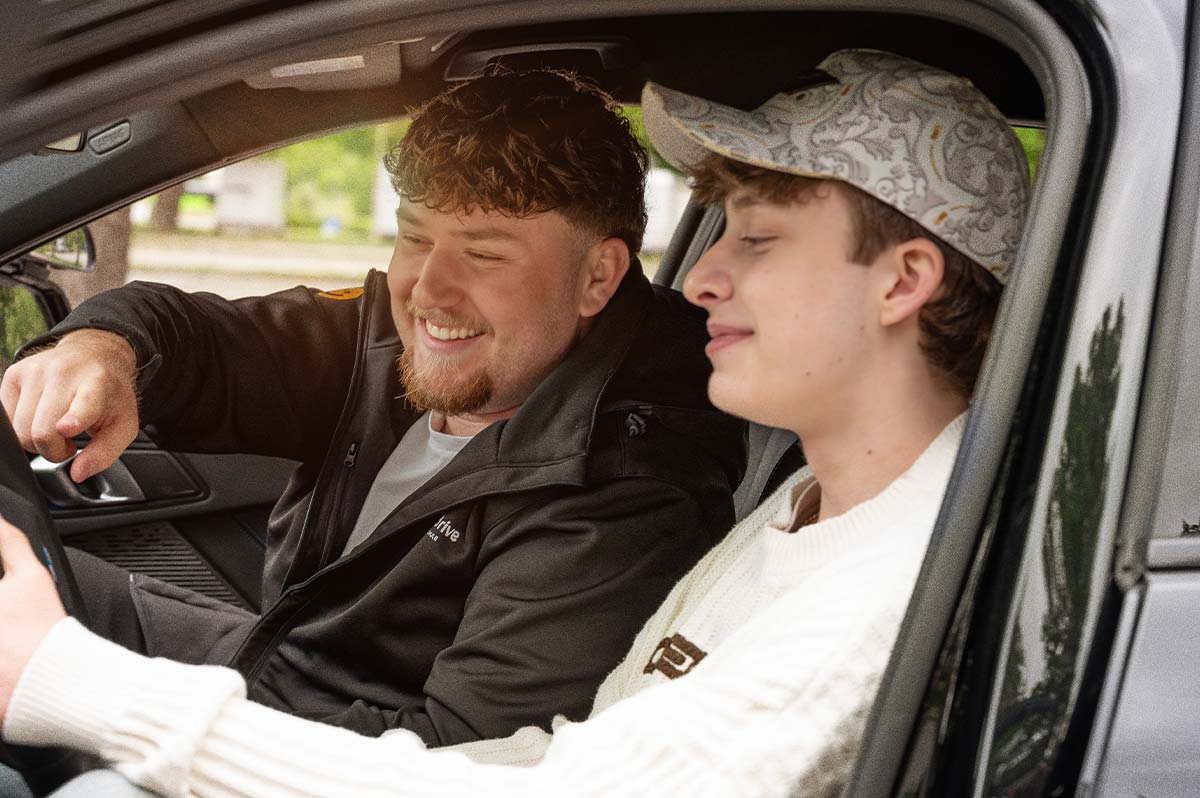 Fahrlehrer und Fahrschüler von Friendly Drive sitzen gemeinsam im Auto während einer Fahrstunde in München.